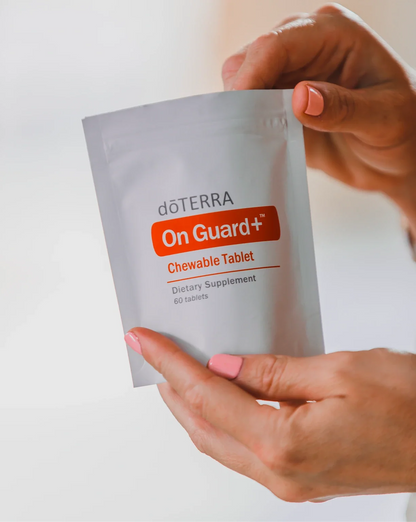 Sachet de comprimés à croquer On Guard+ dōTERRA tenu à deux mains