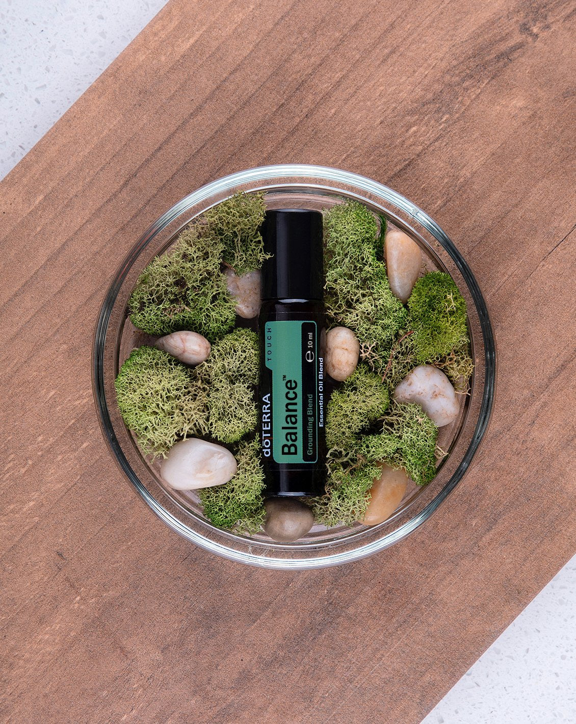 Balance Touch dōTERRA, flacon dans une coupe de mousse et de galets