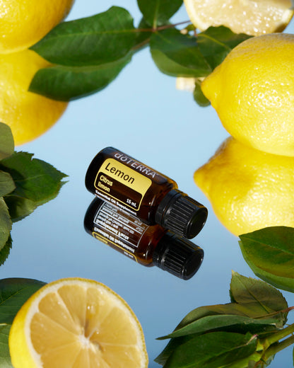 Citron huile essentielle dōTERRA, avec des citrons et des feuilles sur fond bleu