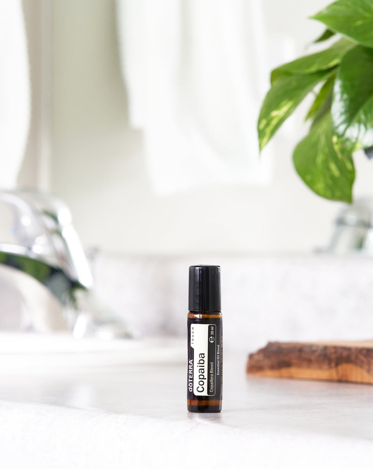 Copaiba Touch dōTERRA, flacon sur le plan d'une salle de bain