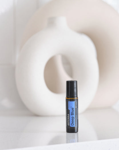 Deep Blue Touch mélange en applicateur à bille dōTERRA, roll-on devant un vase blanc