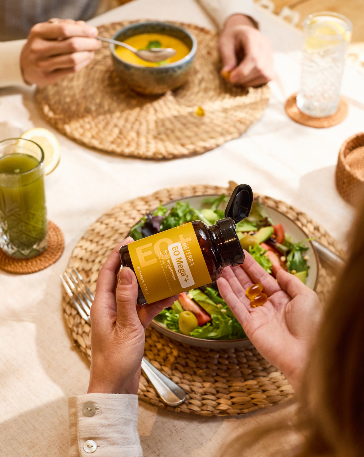 Gélules EO Mega+ dōTERRA, flacon au-dessus d'une salade