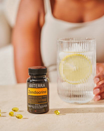 Gélules Zendocrine dōTERRA, flacon et verre d'eau citronnée