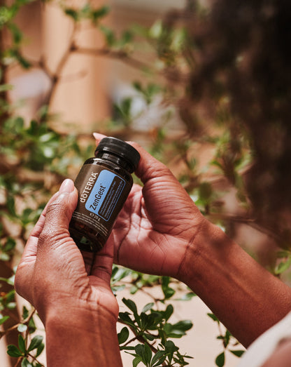 Gélules ZenGest dōTERRA, flacon tenu entre les mains