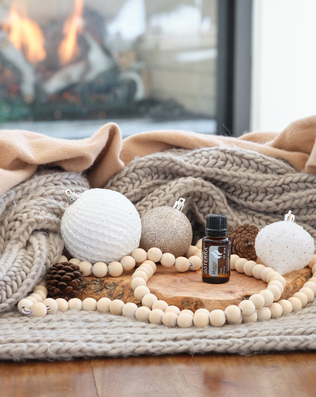 Hygge dōTERRA, flacon sur un plaid tricoté au coin du feu