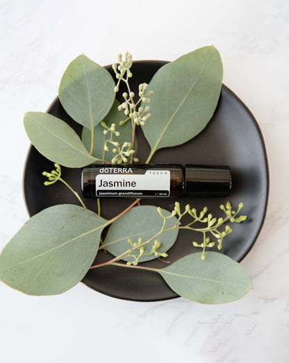 Jasmin Touch dōTERRA, flacon sur une assiette avec de l'eucalyptus