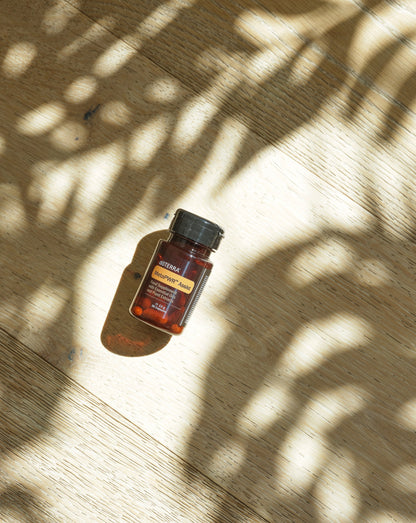 MetaPWR Assist dōTERRA, flacon dans les ombres de feuillage