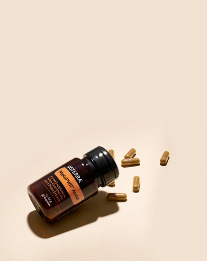 MetaPWR Assist dōTERRA, flacon couché avec capsules sur fond beige