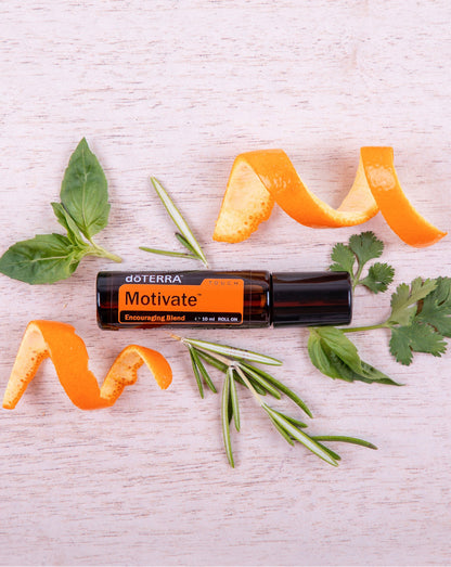 Motivate Touch dōTERRA, flacon entouré de zestes d'orange et d'herbes fraîches