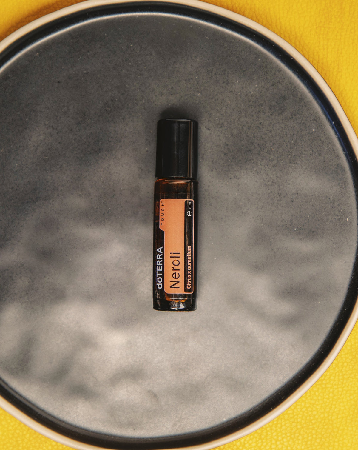 Néroli Touch dōTERRA, flacon sur un plateau en pierre