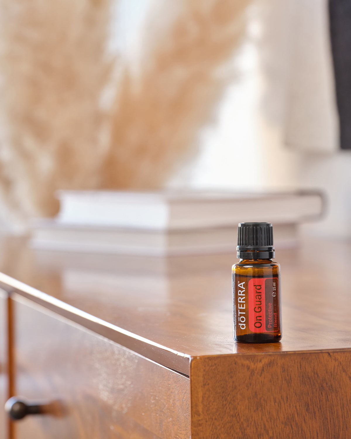 On Guard mélange d'huiles essentielles dōTERRA, flacon avec une bougie