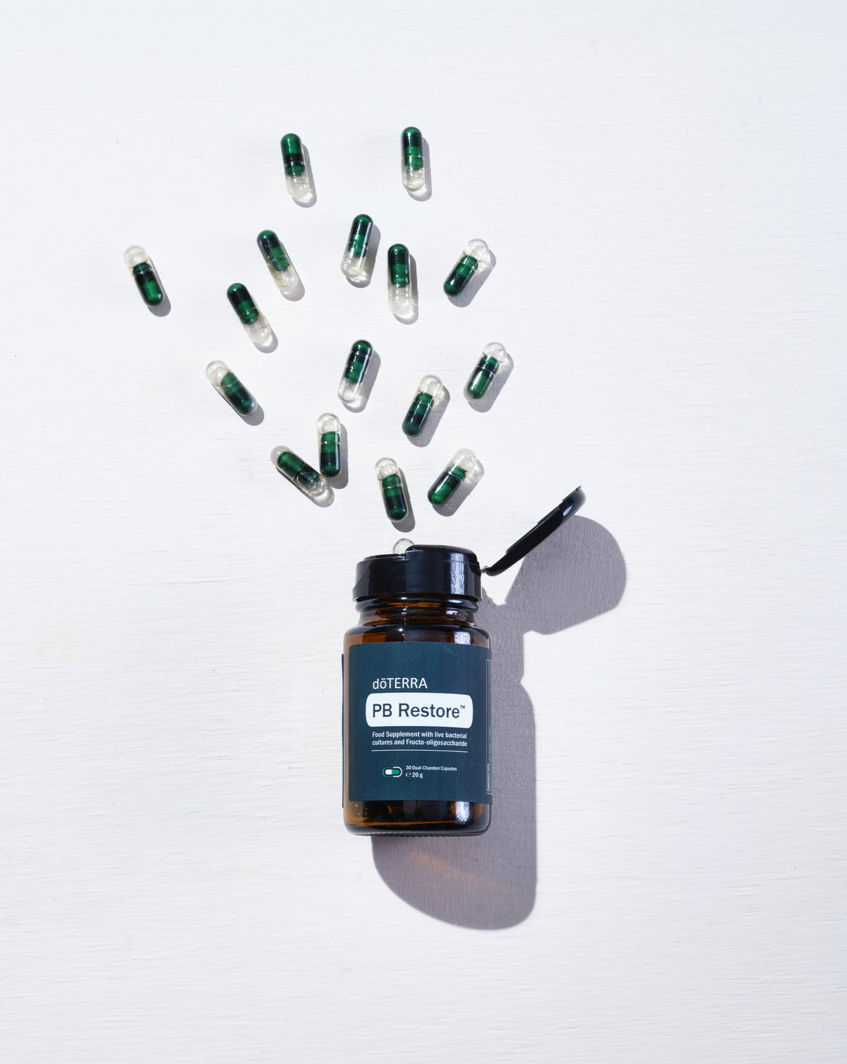 PB Restore dōTERRA, flacon et gélules sur fond blanc
