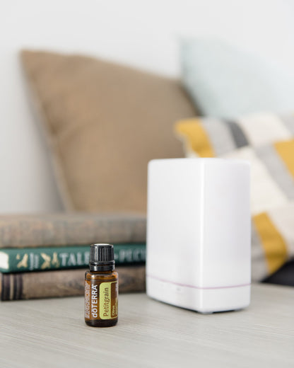 Petitgrain huile essentielle dōTERRA, à côté d'un diffuseur dans un salon
