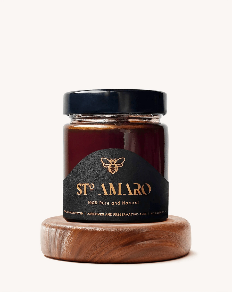 Pot de miel multifloral STo AMARO fermé, posé sur un socle en bois rond