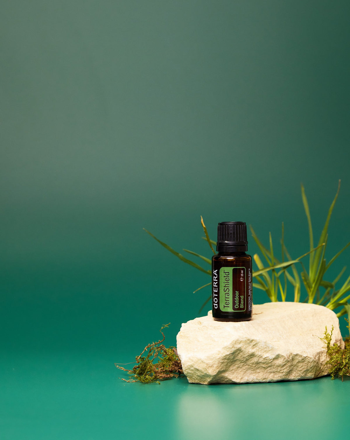TerraShield dōTERRA, flacon sur une pierre parmi les herbes