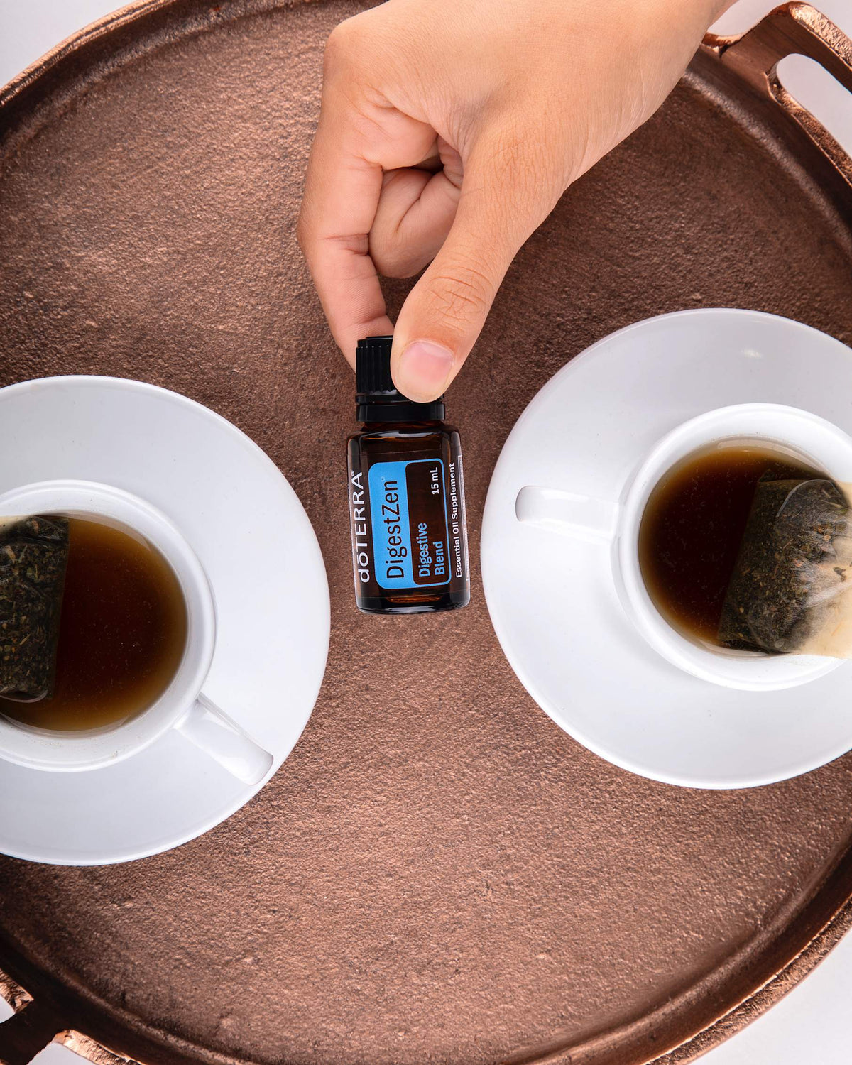 ZenGest mélange d'huiles essentielles dōTERRA, flacon avec une tasse de thé